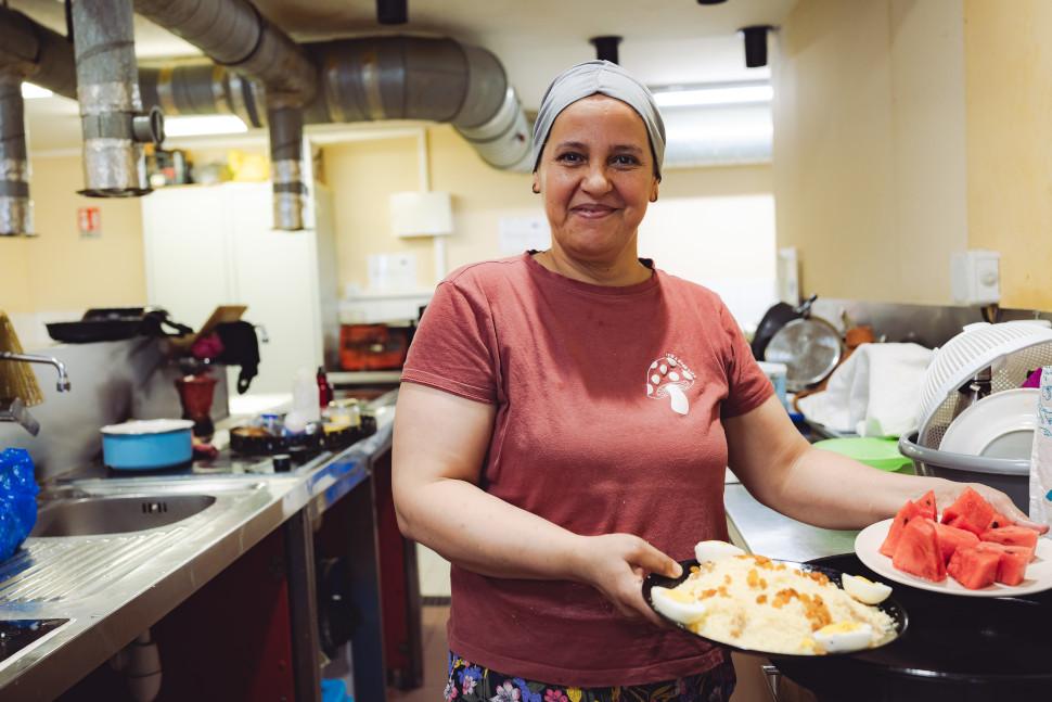 Aide alimentaire, la fin des solutions uniques Une femme tend des plats cuisinés