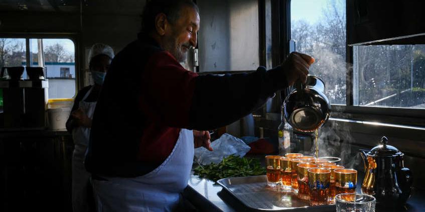 Idder, résident sur le Bateau, verse le thé dans les verres adaptés