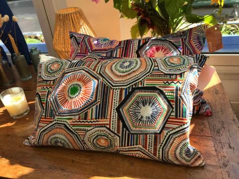 Des coussins sur un meuble issus du travail d'upcycling de l'Armée du Salut