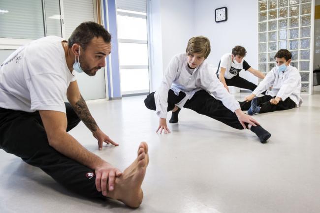 Un entraineur avec des jeunes qui font du judo Un entraineur avec des jeunes qui font du judo