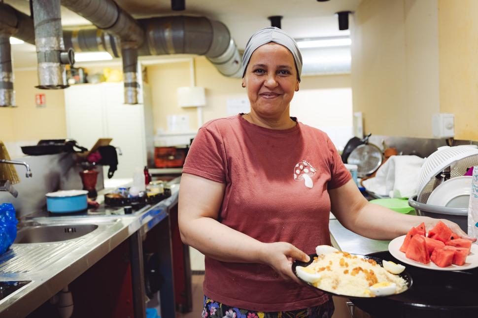Une femme tend des plats cuisinés