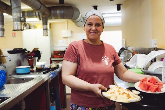 Une femme tend des plats cuisinés