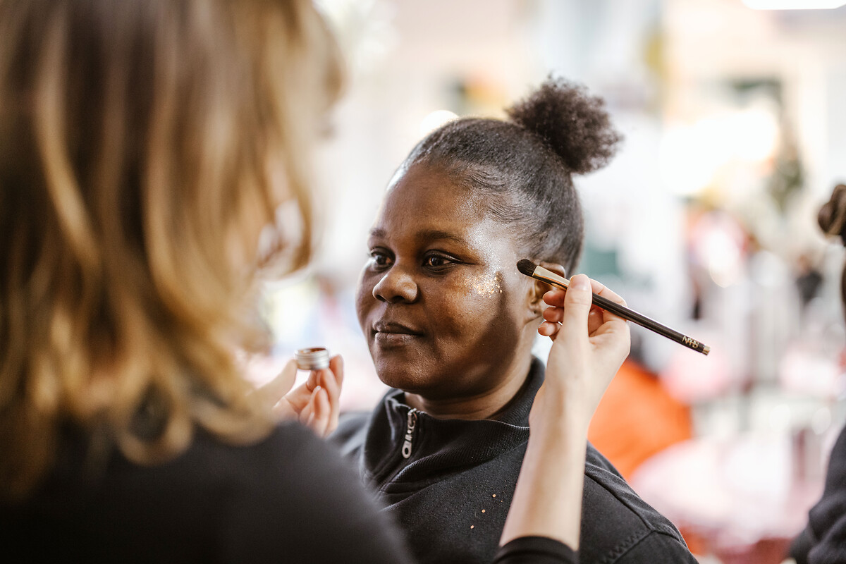 Julienne Kouladé, bénéficiaire de la Cocotte se fait maquiller lors de la fête de Noel, organisée à la Cocotte, à Paris, jeudi 19 décembre 2024.