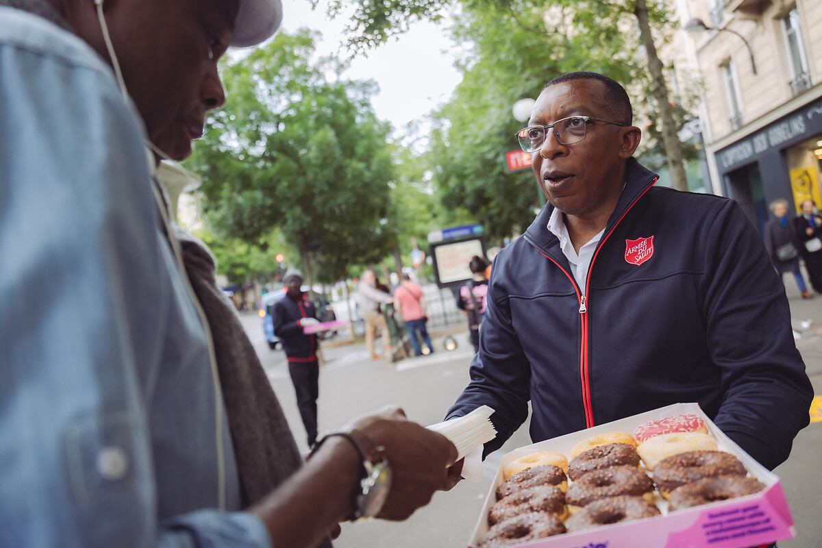 Au 26 Av. des Gobelins, 75013 Paris, à la sortie du métro, le 6 juin 2025, l’Armée du Salut a célébré le Donut Day, une tradition d’origine américaine, afin de rendre hommage aux « Doughnut Girls », ces femmes bénévoles qui, durant la Première et la Seconde Guerre mondiale, apportaient réconfort et soutien aux soldats en leur distribuant des donuts sur le front. Cette journée, désormais célébrée dans plusieurs pays, est aussi l’occasion pour l’Armée du Salut de sensibiliser le public à ses actions et de faire connaître ses établissements et programmes sociaux à travers toute la France. L’organisation, présente dans plus de 130 pays, œuvre notamment dans l’accueil des personnes en difficulté, la lutte contre l’exclusion et l’aide alimentaire. À travers le Donut Day, elle invite chacun à découvrir ses missions et à soutenir ses initiatives solidaires. Cette année, l’opération a bénéficié du partenariat de Doony’s, qui a offert plusieurs dizaines de milliers de donuts distribués dans les établissements de l’association à travers le pays.