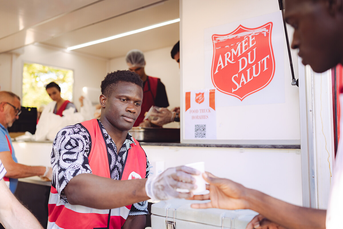 Le bénévole Ibrahima Rama distribue du café.