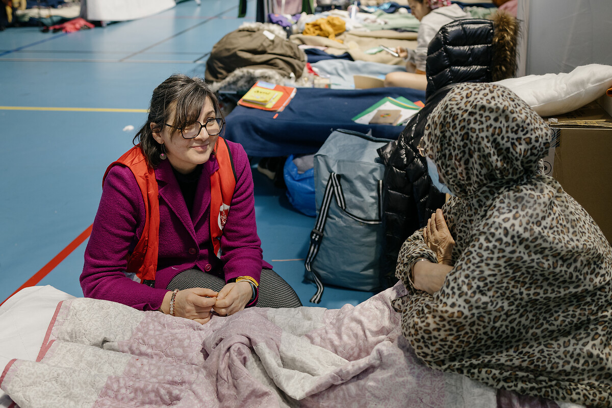 Valentina CENTENARO , échange des mots réconfortants avec une dame sans domicile fixe, hébergée temporairement au gymnase Renoir à Paris