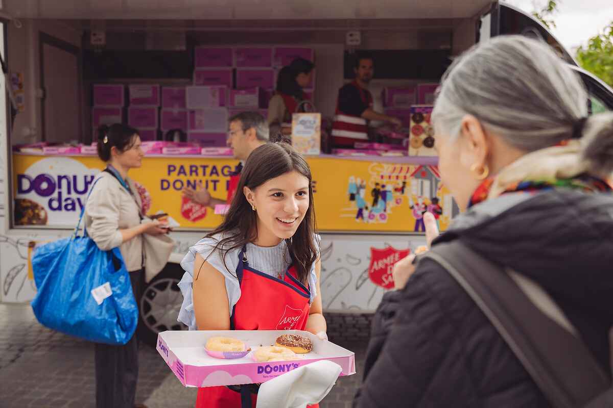 Place Henri Langlois V, autour d'un foodtruck, le 6 juin 2025, l’Armée du Salut a célébré le Donut Day, une tradition d’origine américaine, afin de rendre hommage aux « Doughnut Girls », ces femmes bénévoles qui, durant la Première et la Seconde Guerre mondiale, apportaient réconfort et soutien aux soldats en leur distribuant des donuts sur le front. Cette journée, désormais célébrée dans plusieurs pays, est aussi l’occasion pour l’Armée du Salut de sensibiliser le public à ses actions et de faire connaître ses établissements et programmes sociaux à travers toute la France. L’organisation, présente dans plus de 130 pays, œuvre notamment dans l’accueil des personnes en difficulté, la lutte contre l’exclusion et l’aide alimentaire. À travers le Donut Day, elle invite chacun à découvrir ses missions et à soutenir ses initiatives solidaires. Cette année, l’opération a bénéficié du partenariat de Doony’s, qui a offert plusieurs dizaines de milliers de donuts distribués dans les établissements de l’association à travers le pays.