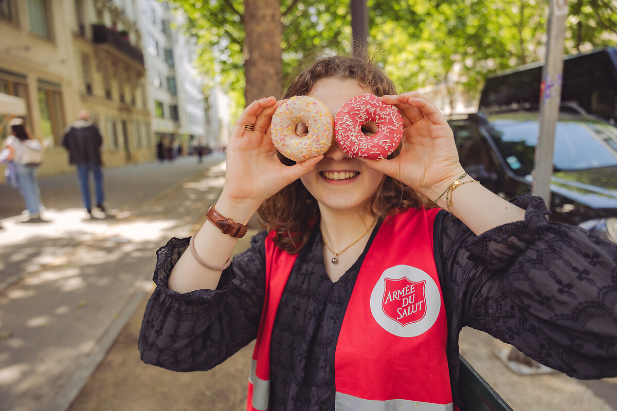 A la halte humanitaire Diderot, le 6 juin 2025, l’Armée du Salut a célébré le Donut Day, une tradition d’origine américaine, afin de rendre hommage aux « Doughnut Girls », ces femmes bénévoles qui, durant la Première et la Seconde Guerre mondiale, apportaient réconfort et soutien aux soldats en leur distribuant des donuts sur le front. Cette journée, désormais célébrée dans plusieurs pays, est aussi l’occasion pour l’Armée du Salut de sensibiliser le public à ses actions et de faire connaître ses établissements et programmes sociaux à travers toute la France. L’organisation, présente dans plus de 130 pays, œuvre notamment dans l’accueil des personnes en difficulté, la lutte contre l’exclusion et l’aide alimentaire. À travers le Donut Day, elle invite chacun à découvrir ses missions et à soutenir ses initiatives solidaires. Cette année, l’opération a bénéficié du partenariat de Doony’s, qui a offert plusieurs dizaines de milliers de donuts distribués dans les établissements de l’association à travers le pays.