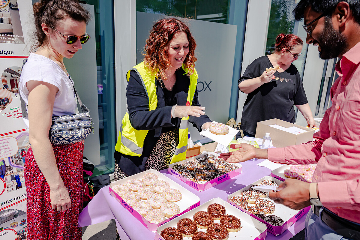 Devant le siège de l'entreprise AXA, des salariés se relaient pour endosser le rôle de bénévole, distribuer des Donuts aux passants et leur parler de l'Armée du Salut.